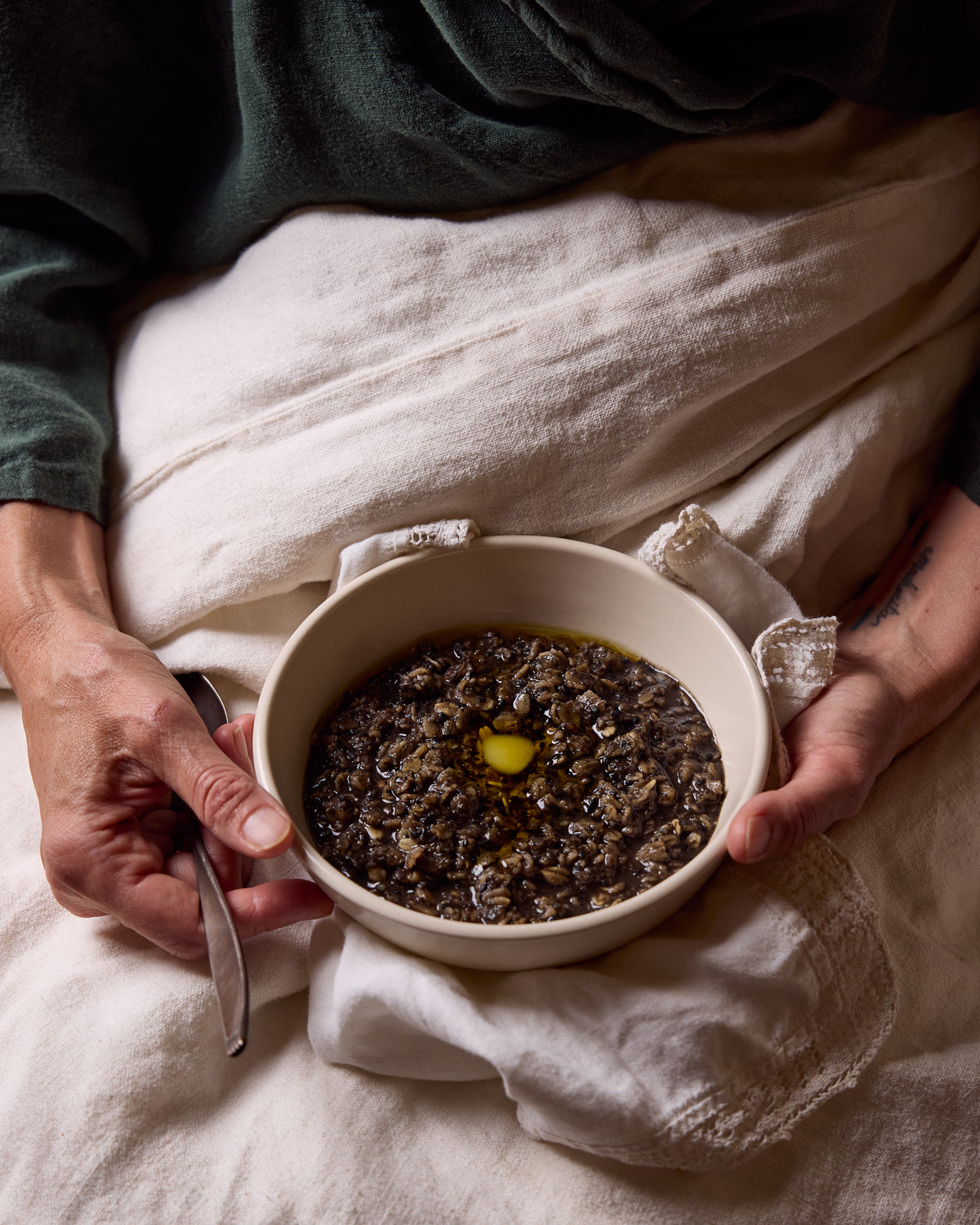 A bowl of Black Sesame Porridge held in bed